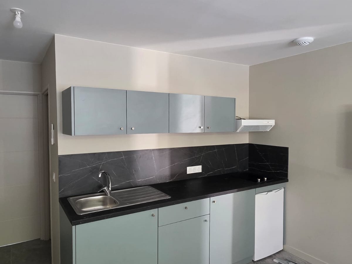 Cuisine sur mesure avec meubles verts et plan noir